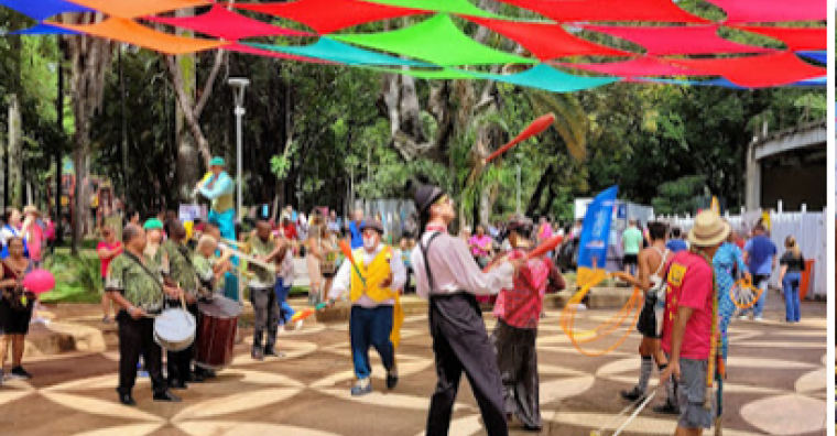 Apresentações diversas de circo em meio ao parque municipal com teto colorido feito de panos