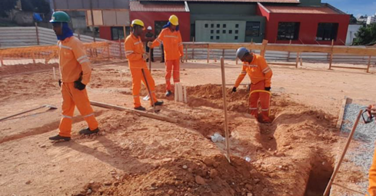 Canteiro de obras onde e vê quatro homens trabalhando