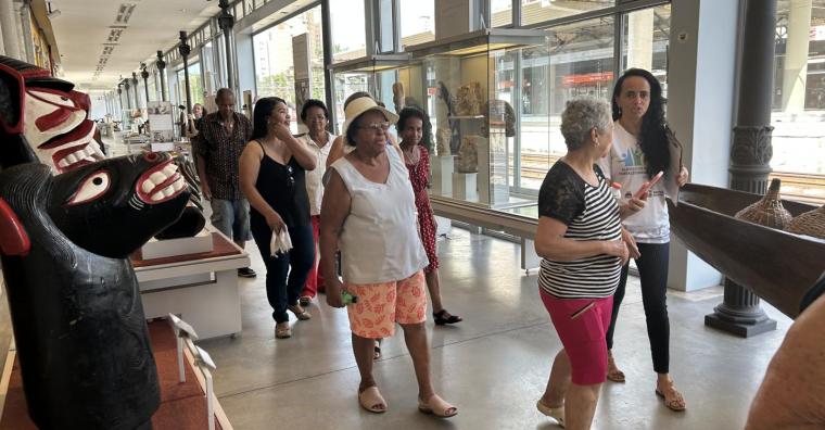 Idosos do CRAS Vila Cemig, acompanhados por monitora, olham para carranca e outros objetos do Museu de Artes e Ofício, durante o dia