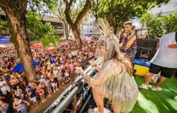 Artista se apresenta em cima de trio elétrico para uma multidão durante festa de Carnaval em Belo Horizonte.
