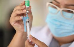 Enfermeira observa vacina contra a Covid-19