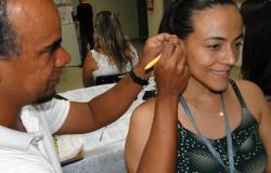 Funcionária da Prefeitura tendo sessão gratuita de auriculoterapia (acupuntura na orelha)
