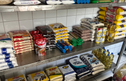 prateleiras de metal com diversos sacos de alimentos empilhados 