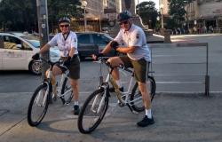 Dois agentes de trânsito da BHTrans de bicicleta, na praça Sete, durante o dia. 