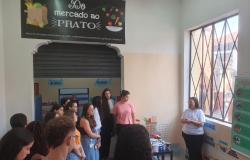 Vários alunos de pé em uma sala Centro de Referência em ouvindo sobre Segurança Alimentar e Nutricional