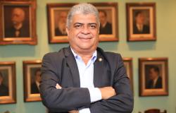 Foto oficial - Claudiney Alves, Secretário Municipal de Assuntos Institucionais Secretário Municipal de Assuntos Institucionais - Claudiney Alves, posa em uma fotografia em local fechado com terno escuro e camisa azul clara.