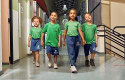 quatro crianças caminham no corredor de um escola