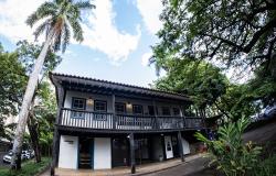 A imagem mostra o o Casarão do MHAB (Museu Histórico Abílio Barreto) em um dia ensolarado. O casarão, de dois andares e arquitetura colonial, é o elemento central da composição.