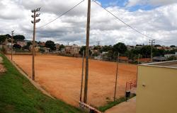 Campo de futebol do Providência, com piso de terra, poste de iluminação e parte gramada na arquibancada