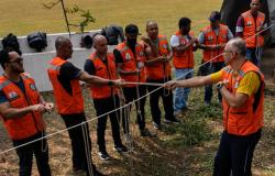 Servidores da Defesa Civil de BH, usando coletes laranjas da instituição, participam de treinamento com cordas