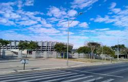 Estádio Minerão ao fundo, céu azulado e avenida vazia