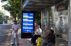 Cinco pessoas aguardam ônibus em ponto da Avenida Afonso Pena