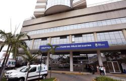  A imagem mostra a fachada do Hospital Metropolitano Dr. Célio de Castro, de gestão da Prefeitura de Belo Horizonte A foto também apresenta um veículo de transporte de saúde estacionado à esquerda.