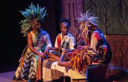 Quatro atores de teatro encenam com figurinos característicos e adereços nas cabeças