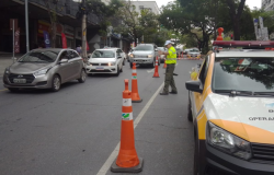 Viatura da BHTRANS parada em uma via interditada com alguns cones de trânsito enquanto agente da BHTRANS orientar motoristas