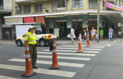 Agente da BHTRANS monitora trânsito interditado em via com cones distribuídos em um faixa de pedestre