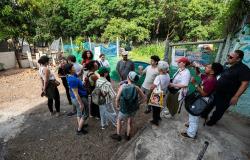 A imagem mostra técnicos de São Paulo em uma roda atentos ao que dizem membros equipes da PBH e do Projeto Territórios da Água. estão em uma área verde, ao ar livre.