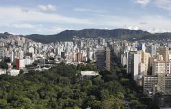 Vista panorâmica da cidade de Belo Horizonte, com imagens de árvores, vários prédios e a Serra do Curral ao fundo