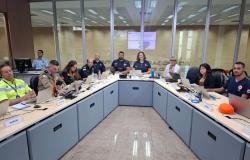 Foto dos integrantes do Posto de Comando, formado por representantes de vários órgãos públicos, sentados ladeados no COP-BH