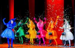 Seis bruxinhas, cada uma de uma cor, se apresentam no palco. 