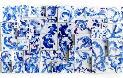 Obra de arte abstrata retangular, composta de mais de trinta quadrados pequenos, de tamanhos diferentes, dispostos em vários níveis de relevos, com fundo brando e pintados de vários tons de azul. 