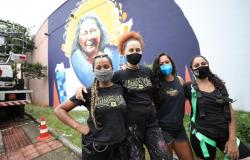 Grafiteiras em frente ao mural "Nós podemos tudo"