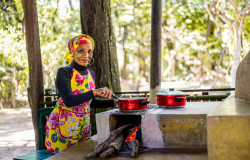 Mulher cozinhando em um fogão à lenha