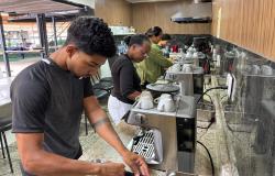 Jovens participam de atividade prática de preparação de café, utilizando máquinas de expresso em um espaço de formação profissional. Durante a atividade, os participantes manuseiam equipamentos e utensílios, desenvolvendo habilidades relacionadas ao preparo e ao serviço de bebidas.