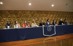 Secretária municipal de Educação, Ângela Dalben, acompanhada de sete pessoas na mesa de abertura da IX Conferência Municipal de Educação. 