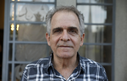 Foto oficial - Afonso Celso Renan Barbosa, Secretário Adjunto de Educação Secretário Adjunto de Educação - Afonso Celso Renan Barbosa, posa em uma fotografia em local aberto com camisa xadrez tom de azul e tracejado em cor branca.
