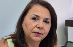 Mulher branca posa ao lado do computador