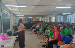 #PARATODOSVEREM: Professora conduz leitura para grupo de crianças sentadas em fileiras, em sala de aula colorida e decorada, acompanhadas por outras educadoras. 