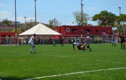 jogadores jogam futebol em campo de grama sintética. 