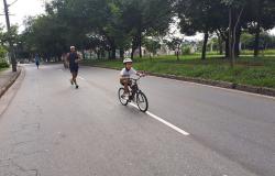 Criança andando de bicicleta na avenida