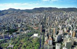 Vista aérea da avenida Afonso Pena, com Parque Municipal à esquerda, abaixo, prédios por todos os lados e a Serra do Curral ao fundo. 