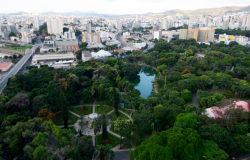 Imagem aérea de Parque Muncipal Américo Renné Giannetti durante o dia. Ao fundo, prédios e horizonte.
