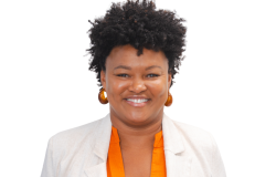 Mulher negra sorrindo, usando brincos e cabelos curto para cima.