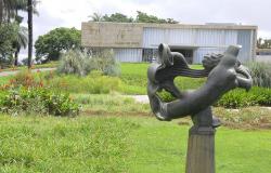 Fachada do Museu de Arte da Pampulha, com escultura do jardim à frente, durante o dia.