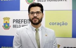 Duander Franco Homem de barba e óculos usando terno claro e gravata beige
