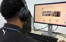 Pessoa utilizando computador com fones de ouvido para acessar curso on-line de ferramentas de design para empreendedores.