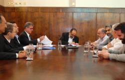 Prefeito Alexandre Kalil assina convênio com a Caixa Econômica Federal no Salão Nobre. Sentados à mesa, quatro membros da equipe da PBH e quatro membros da Caixa Econômica Federal.