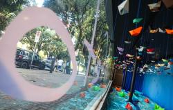 Vitrine com barquinhos de papel pendurados de várias cores