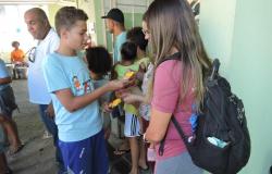 Adolescentes recebem material informativo na porta do evento