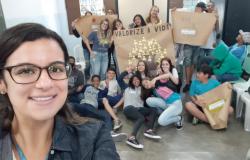 Selfie de mulher com mais de doze jovens com cartazes sobre o combate à automutilação. 