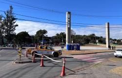 Fotografia em dia ensolarado da Praça da Pampulha, com uma caminhonete amarela da BHTRANS estacionada em uma ilha de trânsito isolada por cones e fita zebrada.