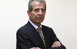 Procurador-Geral do Município - Hércules Guerra, posa em uma fotografia em local fechado com terno de tom escuro, gravata e camisa de cor azul claro.