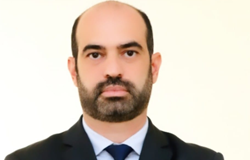 Foto oficial - Luiz Gustavo Levate, Subprocurador-Geral Fiscal Subprocurador-Geral Fiscal - Luiz Gustavo Levate, posa em uma fotografia em local fechado com terno de tom escuro, gravata e camisa de cor azul claro.