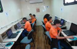 Seis jovens estão sentados em frente a computadores do Projeto Conexão Aberta. 