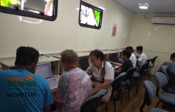 alunos do Telecentro acessando a internet gratuitamente e outros aprendendo a utilizar com a ajuda de um monitor.