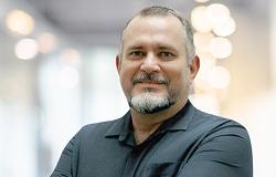 Foto oficial - Carlos Roberto Bortone, Diretor de Sistemas e Informação da Prodabel (DSI - PB) Diretor de Sistemas e Informação da Prodabel (DSI - PB) - Carlos Roberto Bortone, posa em espaço fechado, usando blusa preta.